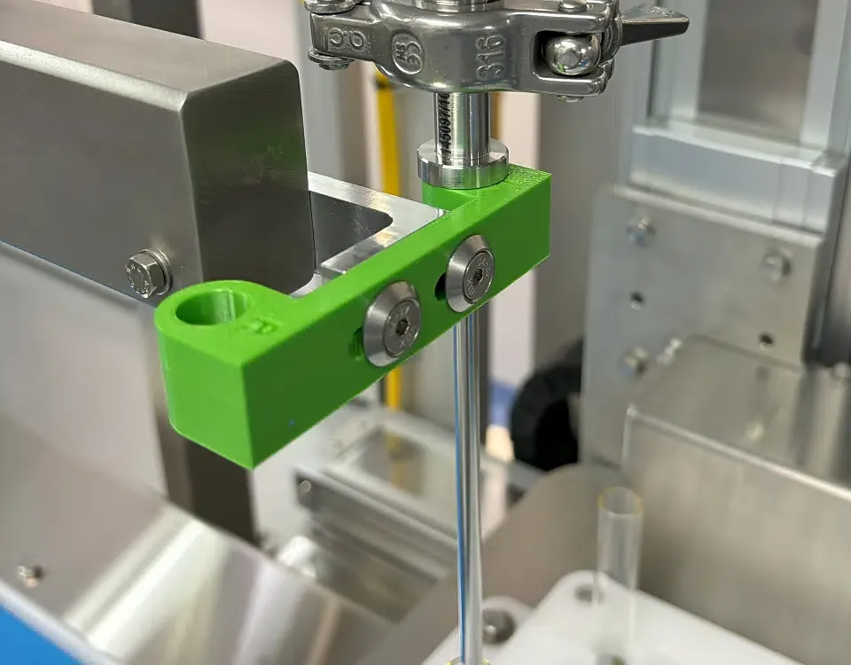 Support de buse imprimé en 3D monté en salle blanche sur équipement inox medtech